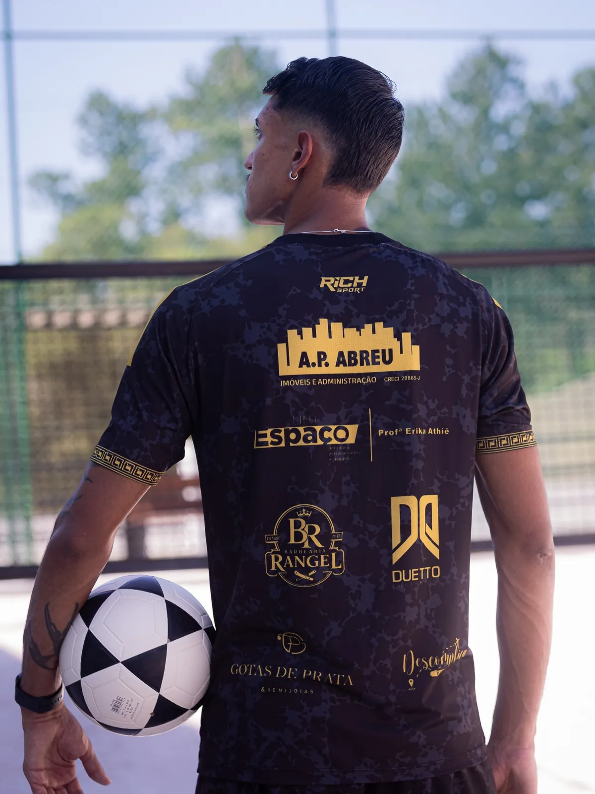 Costas do uniforme da Templo com os patrocinadores, bola na mão